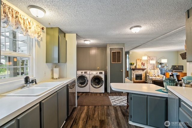 4224 N Brooks Rd, Medical Lake, WA 99022 - laundry area with washing machine and clothes dryer, dark wood-style flooring, a stone fireplace, and a textured ceiling