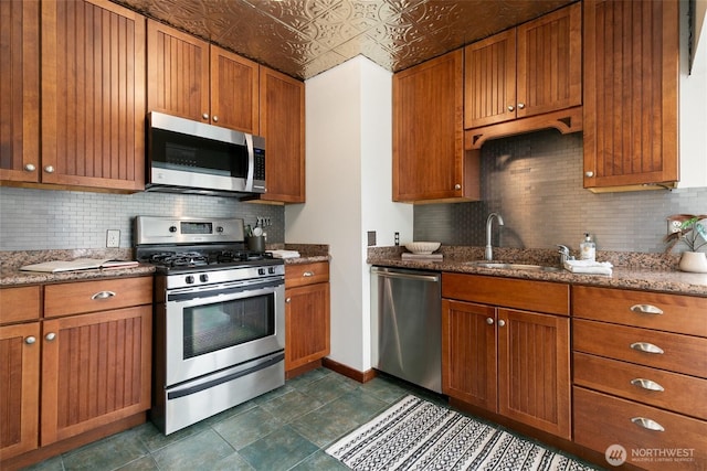 3929 SW Elmgrove St, Seattle, WA 98136 - kitchen with stainless steel appliances, decorative backsplash, light stone countertops, brown cabinetry, and an ornate ceiling