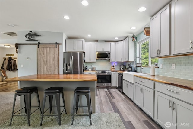 822 Filbert Rd, Cle Elum, WA 98922 - kitchen with stainless steel appliances, wooden counters, a sink, a breakfast bar, and light wood-style floors