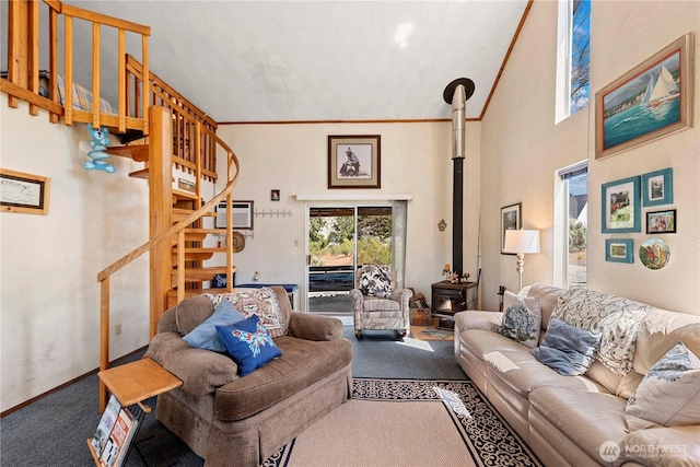 245 Lakeview Ave, Orondo, WA 98843 - carpeted living area featuring a wood stove, stairway, a high ceiling, a wall mounted air conditioner, and baseboards