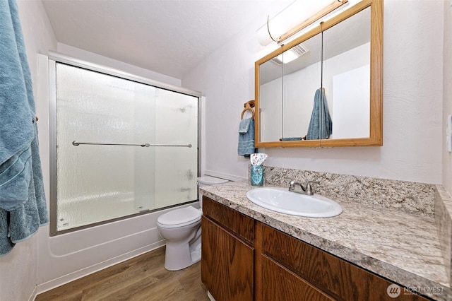 944 Barnhard St, Shelton, WA 98584 - full bath with wood finished floors, vanity, toilet, and shower / bath combination with glass door