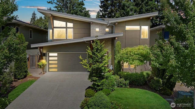 12126NE 106th Pl, Kirkland, WA 98033 - contemporary home with concrete driveway, a garage, and stone siding