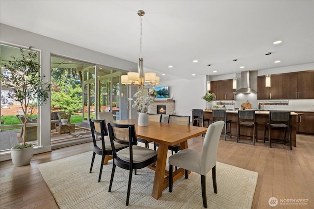 12126NE 106th Pl, Kirkland, WA 98033 - dining room featuring a chandelier, light wood-type flooring, recessed lighting, and a fireplace