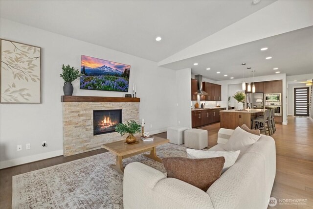 12126NE 106th Pl, Kirkland, WA 98033 - living room featuring light wood-style flooring, a fireplace, vaulted ceiling, recessed lighting, and baseboards