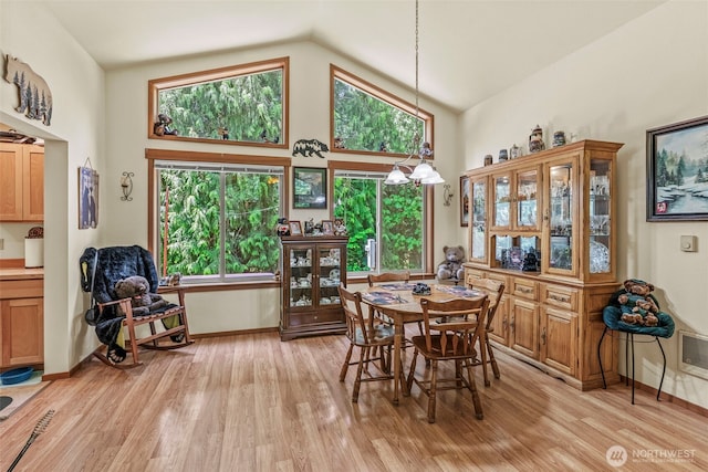 19243 Kiona Rd, Randle, WA 98377 - dining area with light wood-type flooring, high vaulted ceiling, and baseboards