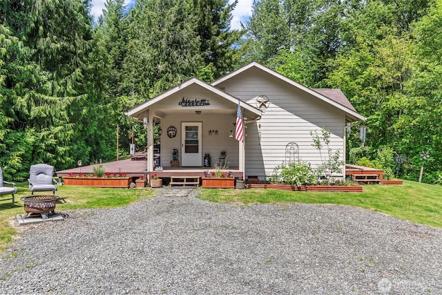 19243 Kiona Rd, Randle, WA 98377 - view of front facade with an outdoor fire pit, covered porch, a front lawn, and crawl space