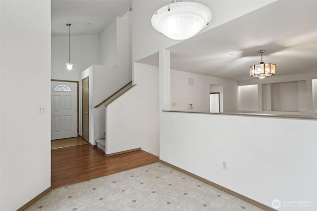 8411 68th Avenue Ct SW, Lakewood, WA 98499 - spare room featuring baseboards, a chandelier, stairway, tile patterned floors, and a high ceiling