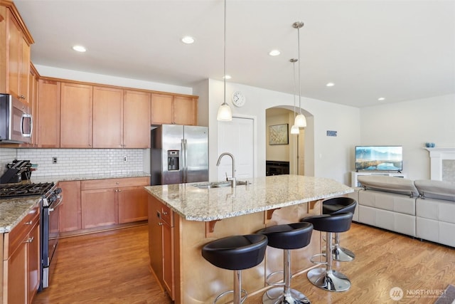 1903 98th Ave SE, Lake Stevens, WA 98258 - kitchen featuring stainless steel appliances, a sink, arched walkways, light wood-style floors, and recessed lighting