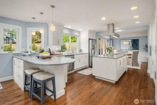 24228 SE 47th St, Sammamish, WA 98029 - kitchen featuring appliances with stainless steel finishes, island range hood, a peninsula, white cabinets, and recessed lighting