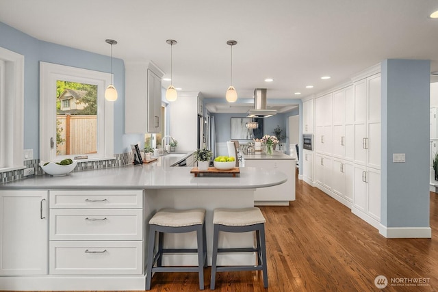 24228 SE 47th St, Sammamish, WA 98029 - kitchen featuring a peninsula, white cabinets, island exhaust hood, and recessed lighting