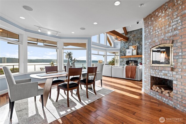 4486 E Harbor Rd, Freeland, WA 98249 - dining space featuring a large fireplace, hardwood / wood-style flooring, a ceiling fan, and a water view