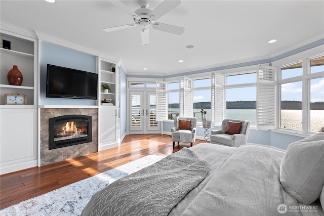 4486 E Harbor Rd, Freeland, WA 98249 - bedroom featuring wood finished floors, ornamental molding, a tile fireplace, french doors, and baseboards
