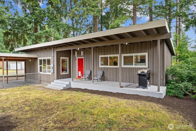 18568 Densmore Ave N, Shoreline, WA 98133 - rear view of house featuring board and batten siding, a yard, and covered porch