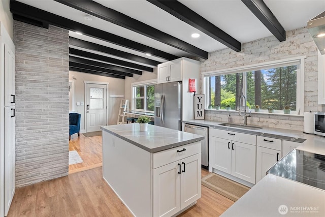 18568 Densmore Ave N, Shoreline, WA 98133 - kitchen featuring stainless steel appliances, white cabinets, backsplash, a center island, and light wood-style flooring