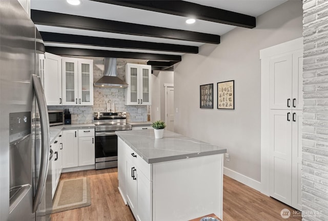18568 Densmore Ave N, Shoreline, WA 98133 - kitchen with wall chimney range hood, appliances with stainless steel finishes, light wood-type flooring, decorative backsplash, and beamed ceiling