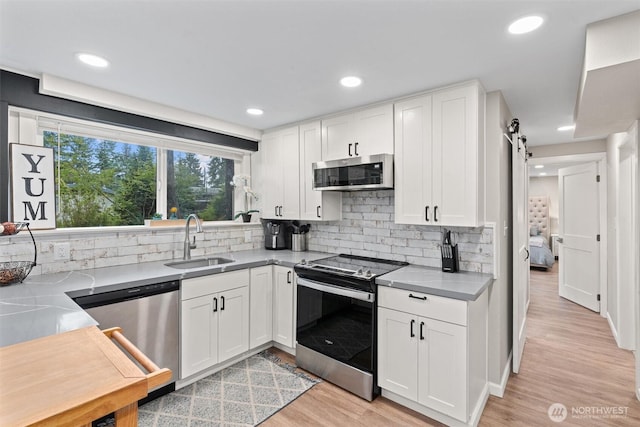 18568 Densmore Ave N, Shoreline, WA 98133 - kitchen featuring appliances with stainless steel finishes, light wood-style flooring, white cabinets, backsplash, and recessed lighting
