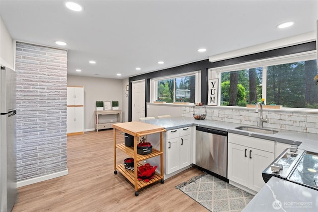 18568 Densmore Ave N, Shoreline, WA 98133 - kitchen featuring appliances with stainless steel finishes, white cabinetry, light wood-style flooring, recessed lighting, and backsplash