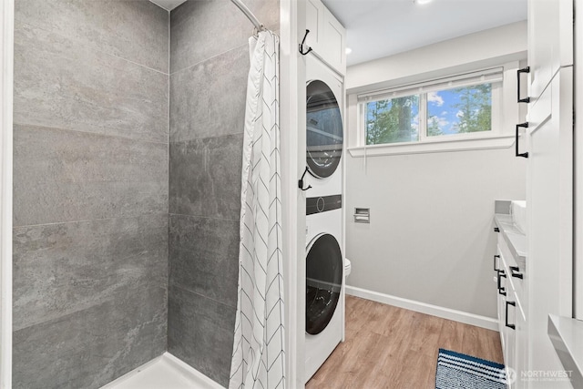 18568 Densmore Ave N, Shoreline, WA 98133 - washroom featuring stacked washer / drying machine and light wood-type flooring