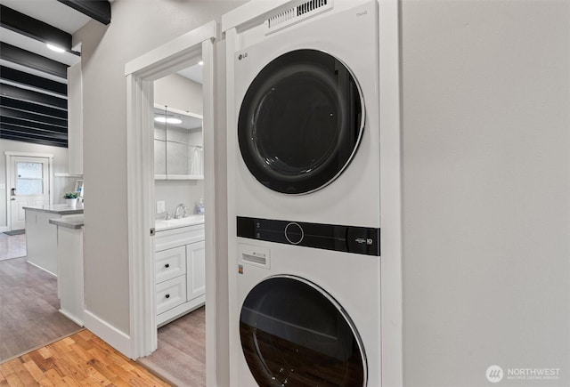 18568 Densmore Ave N, Shoreline, WA 98133 - washroom featuring estacked washer and dryer and light wood-style floors