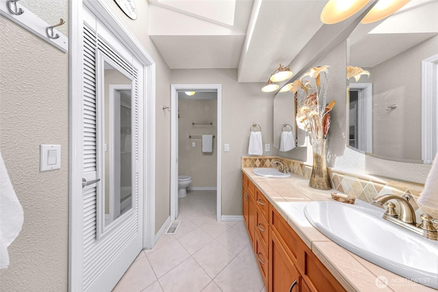 3026 E Alpine Dr, Bellingham, WA 98226 - bathroom featuring toilet, double vanity, tile patterned flooring, a closet, and baseboards