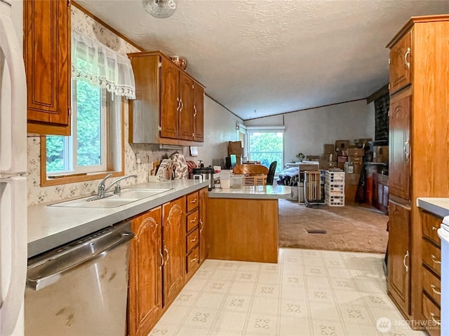 31600 126th Ave SE Unit 129, Auburn, WA 98092 - kitchen with dishwasher, a peninsula, brown cabinetry, a sink, and lofted ceiling