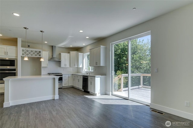 2403 79th Ave SE Unit 110, Tumwater, WA 98501 - kitchen with appliances with stainless steel finishes, wall chimney exhaust hood, dark wood-style floors, decorative backsplash, and recessed lighting