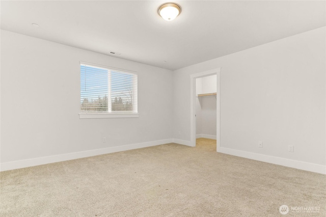 2403 79th Ave SE Unit 110, Tumwater, WA 98501 - unfurnished bedroom featuring light colored carpet, baseboards, and a walk in closet
