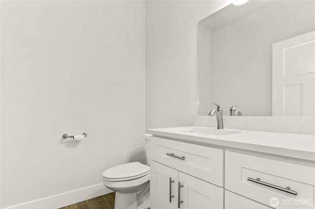 2403 79th Ave SE Unit 110, Tumwater, WA 98501 - half bathroom with vanity, baseboards, toilet, and wood finished floors
