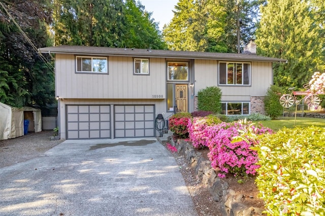 10908 151st St E, Puyallup, WA 98374 - raised ranch featuring a garage, concrete driveway, and a chimney