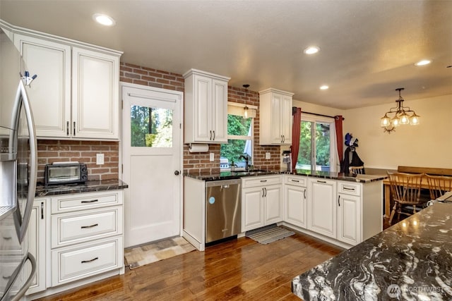 10908 151st St E, Puyallup, WA 98374 - kitchen featuring stainless steel appliances, white cabinetry, wood finished floors, healthy amount of natural light, and recessed lighting