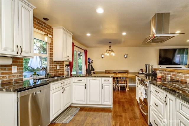 10908 151st St E, Puyallup, WA 98374 - kitchen featuring stainless steel appliances, decorative backsplash, white cabinetry, hardwood / wood-style flooring, and hanging light fixtures