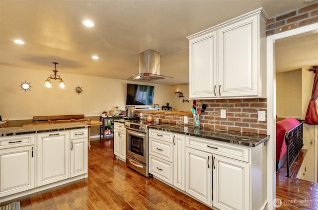 10908 151st St E, Puyallup, WA 98374 - kitchen featuring stainless steel electric range, wood finished floors, a peninsula, decorative backsplash, and recessed lighting