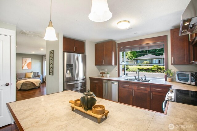 13632 SE Fairwood Blvd, Renton, WA 98058 - kitchen with stainless steel appliances, a sink, light countertops, pendant lighting, and ventilation hood