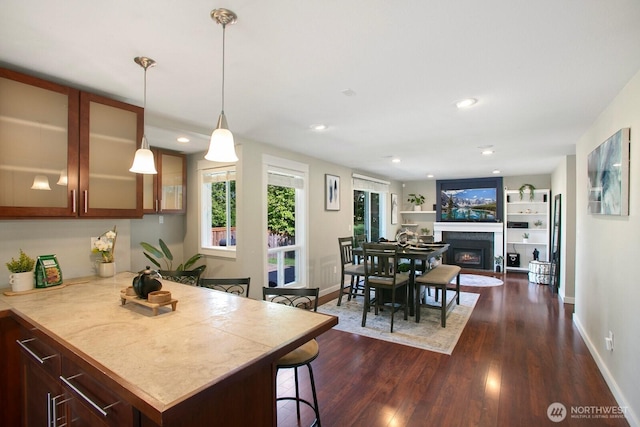 13632 SE Fairwood Blvd, Renton, WA 98058 - kitchen featuring dark wood-type flooring, baseboards, light countertops, a warm lit fireplace, and recessed lighting
