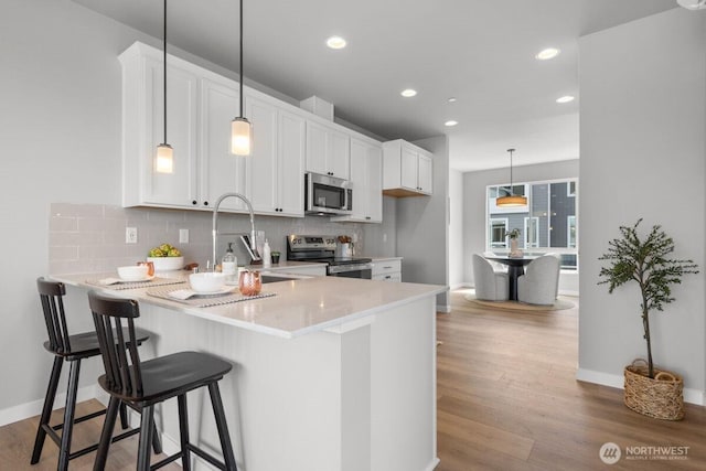 15726 40th Ave W Unit B2, Lynnwood, WA 98087 - kitchen featuring stainless steel appliances, a peninsula, decorative backsplash, light countertops, and a sink