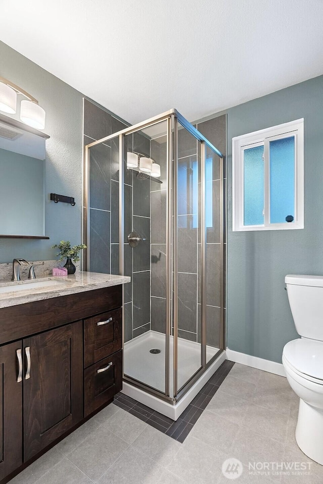 14520 78th Ave NE, Kenmore, WA 98028 - full bath with toilet, vanity, a shower stall, tile patterned floors, and baseboards
