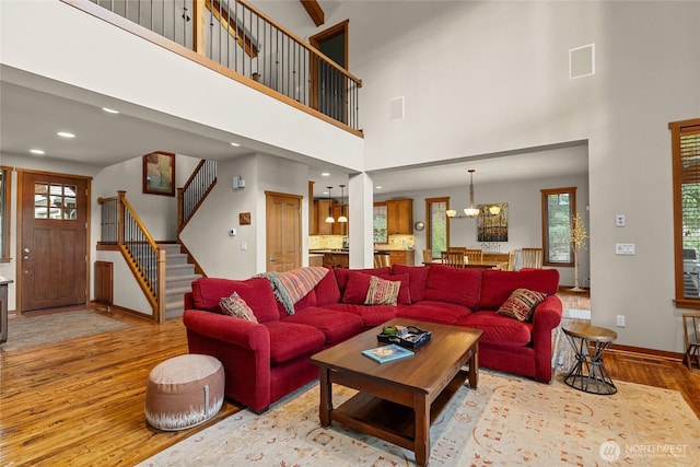 2101 Coal Mine Way, Cle Elum, WA 98922 - living area featuring light wood-type flooring, baseboards, stairway, a chandelier, and a high ceiling