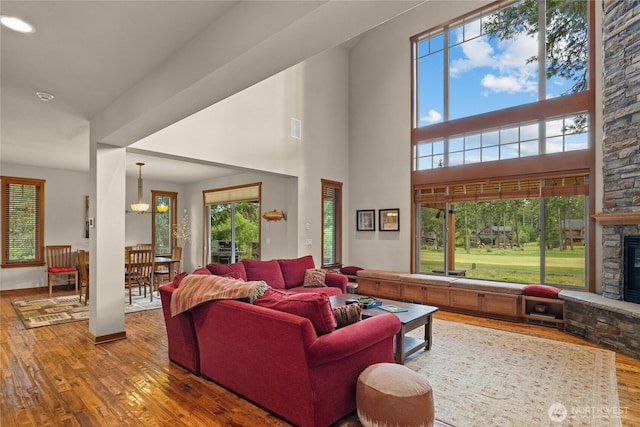 2101 Coal Mine Way, Cle Elum, WA 98922 - living area with hardwood / wood-style flooring, a stone fireplace, a chandelier, and a high ceiling