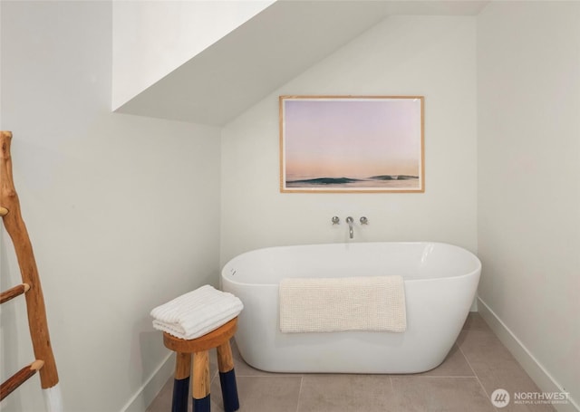 8811 SW Quartermaster Dr, Vashon, WA 98070 - bathroom with a freestanding tub, tile patterned floors, baseboards, and lofted ceiling