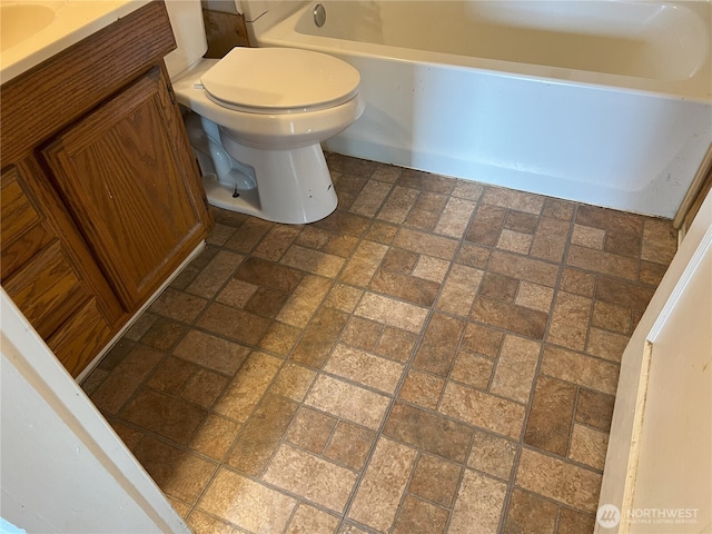 211 E Cherry St, Centralia, WA 98531 - bathroom featuring toilet, a bath, vanity, and brick patterned flooring