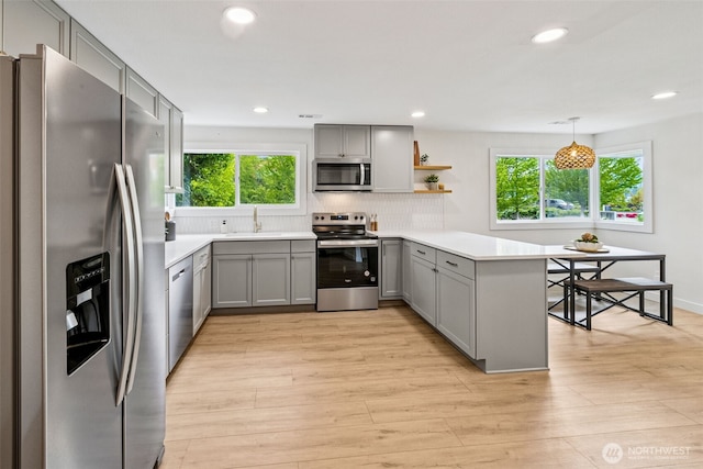 2228 Cinkovich St, Enumclaw, WA 98022 - kitchen with appliances with stainless steel finishes, gray cabinets, a peninsula, open shelves, and tasteful backsplash
