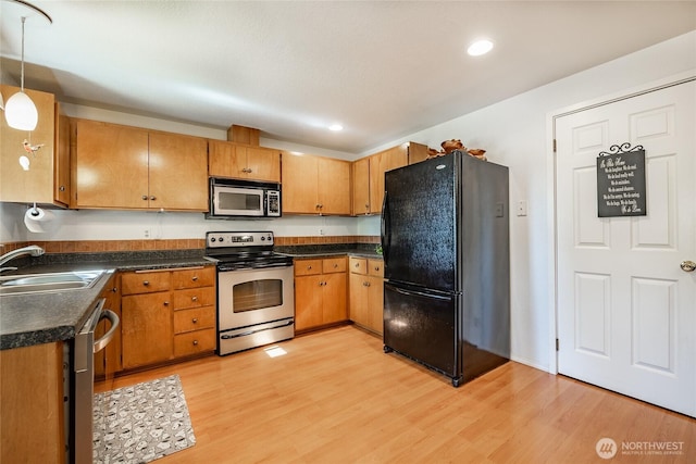 8459 Catalina Ct, Blaine, WA 98230 - kitchen with appliances with stainless steel finishes, a sink, dark countertops, light wood-style flooring, and recessed lighting