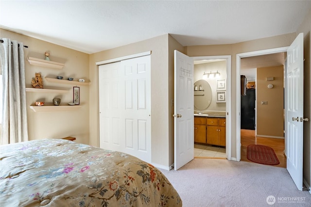 8459 Catalina Ct, Blaine, WA 98230 - bedroom featuring light carpet, a closet, a sink, ensuite bathroom, and baseboards