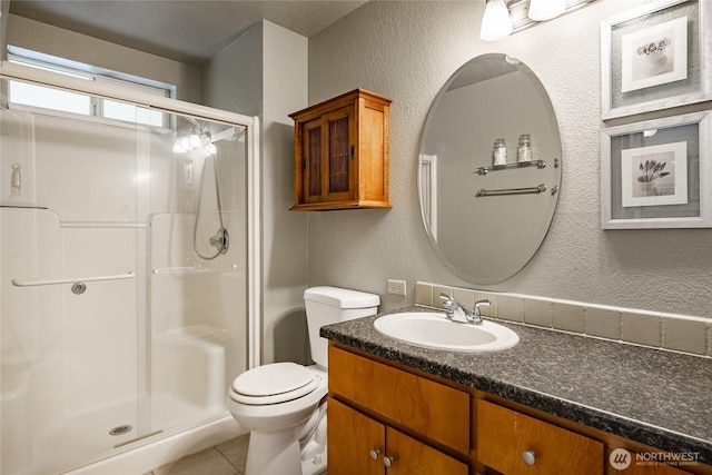 8459 Catalina Ct, Blaine, WA 98230 - bathroom featuring a textured wall, a shower stall, vanity, toilet, and tile patterned floors
