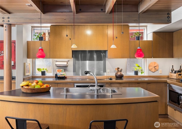 2466 Westlake Ave N Unit 5, Seattle, WA 98109 - kitchen with stainless steel microwave, a sink, decorative light fixtures, wooden ceiling with exposed beams, and a kitchen breakfast bar