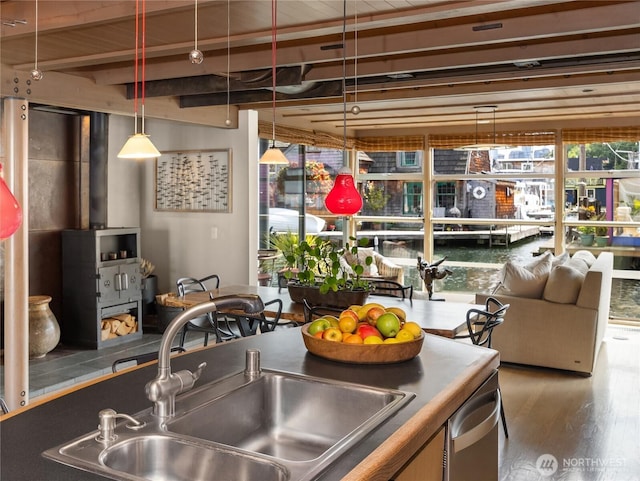 2466 Westlake Ave N Unit 5, Seattle, WA 98109 - kitchen with a sink, wood finished floors, a wood stove, beam ceiling, and dark countertops
