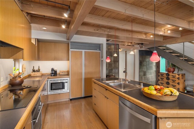 2466 Westlake Ave N Unit 5, Seattle, WA 98109 - kitchen featuring built in appliances, wooden ceiling with exposed beams, light wood-style floors, modern cabinets, and a sink