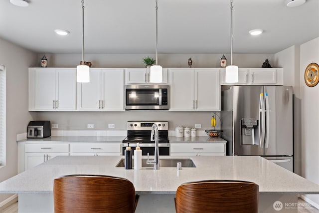 15013 Iverson Loop SE, Yelm, WA 98597 - kitchen with appliances with stainless steel finishes, a kitchen island with sink, white cabinetry, and a sink
