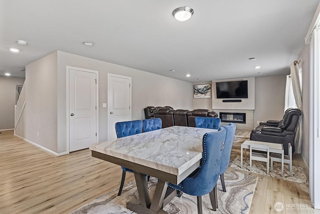 15013 Iverson Loop SE, Yelm, WA 98597 - dining space with light wood-type flooring, a glass covered fireplace, baseboards, and recessed lighting
