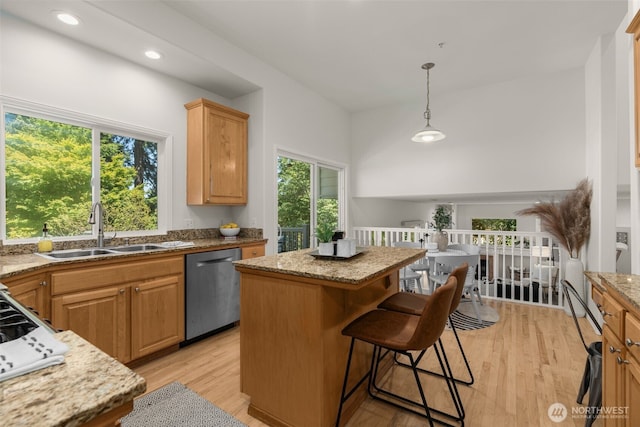 2024 N 145th St, Shoreline, WA 98133 - kitchen with dishwasher, a sink, a kitchen island, light wood-type flooring, and light stone countertops
